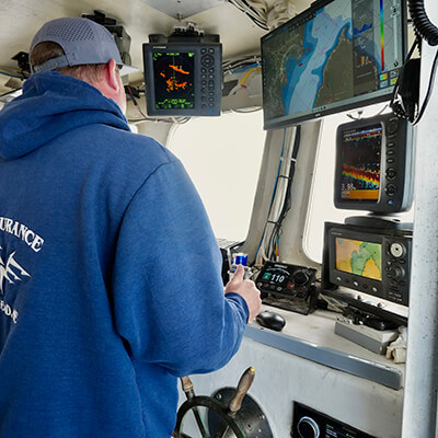 captain of fishing vessel navigating boat